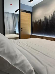 a bedroom with a bed and a window with trees at Modern Mountain Kolasin in Kolašin