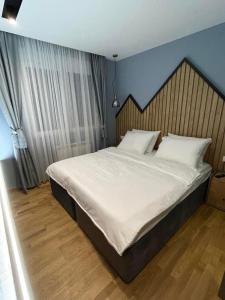 a bedroom with a large bed with a wooden headboard at Modern Mountain Kolasin in Kolašin