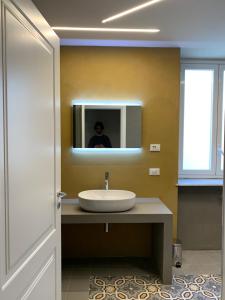 a man taking a picture of a bathroom with a sink at Suite del Ponte Normanno in Palermo