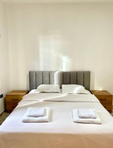 Me & You Hostel في تيرانا: سرير ابيض كبير عليه منشفتين بيضاء