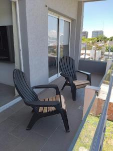 2 sillas sentadas en el balcón de una casa en MIRADORES DEL BOULEVAR en Tigre