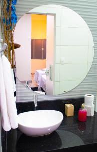 a bathroom with a sink and a mirror at Pousada Raio de Sol in São João Batista do Glória