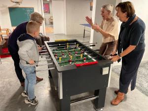 a group of people standing around a table with a foosball at DOS22 Vakantiewoning I De Haan Wenduine in Zuienkerke