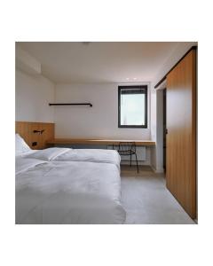 um quarto com uma cama, uma secretária e uma janela em DOS22 Vakantiewoning I De Haan Wenduine em Zuienkerke