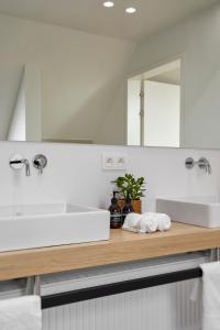 bagno con lavandino bianco e specchio di DOS22 Vakantiewoning I De Haan Wenduine a Zuienkerke
