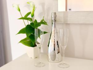 two wine glasses and a plant on a counter at Hangar Inn in Fiumicino