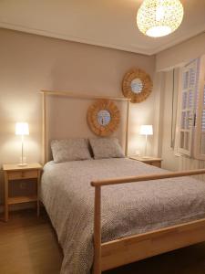 a bedroom with a bed with two lamps and two tables at CASAMENTERA in Mentera-Barruelo