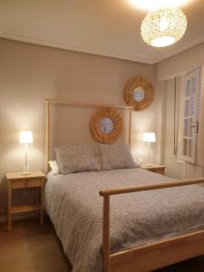 a bedroom with a bed with two tables and two lamps at CASAMENTERA in Mentera-Barruelo