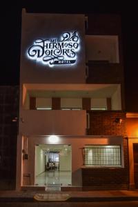 un panneau sur le côté d'un bâtiment la nuit dans l'établissement HOTEL MI HERMOSO DOLORES, à Dolores Hidalgo