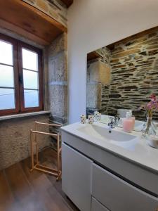 a bathroom with a sink and a stone wall at O Chouzal in Arouca +75 photos