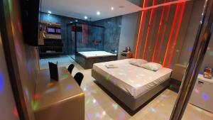 a bedroom with a bed and a shower in it at Desejo Motel in Araçoiaba da Serra