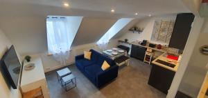 a living room with a blue couch and a kitchen at Le Deauvillais - Appartement Plein Centre - 4 pers - 2 mn plage - Idéal Famille in Deauville
