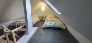 a small room with two beds in a attic at Le Deauvillais - Appartement Plein Centre - 4 pers - 2 mn plage - Idéal Famille in Deauville