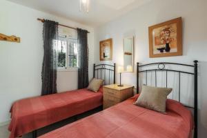 ein Schlafzimmer mit zwei Betten und einem Fenster in der Unterkunft Perfect Family Apartment in Acapulco Playa, Nerja in Nerja