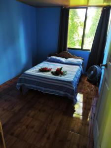 Una habitación azul con una cama con flores. en Amphibia House, en Agua Azul