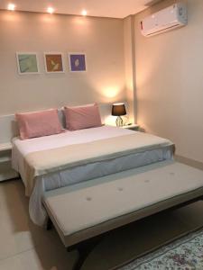 ein Schlafzimmer mit einem großen Bett mit rosa Kissen in der Unterkunft Baruch Hotel in Araguaína