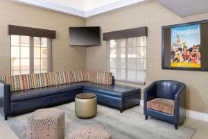 ein Wohnzimmer mit einem Sofa und einem Stuhl in der Unterkunft Best Western Plus Raffles Inn & Suites in Anaheim