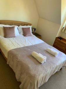 a bedroom with a bed with two towels on it at Bright House with Garden & Patio in Market Town in Inverurie