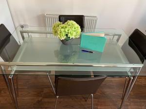 a glass table with a laptop and a plant on it at Bright House with Garden & Patio in Market Town in Inverurie