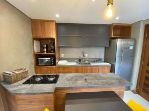 a kitchen with a stove and a refrigerator at Praia do Forte Ohana Residence in Praia do Forte
