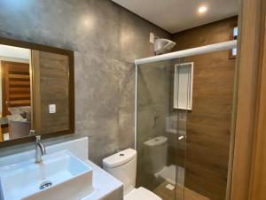 a bathroom with a sink and a toilet and a shower at Praia do Forte Ohana Residence in Praia do Forte