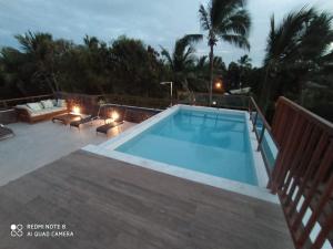 a swimming pool on a deck with a patio and a pool overview at Praia do Forte Ohana Residence in Praia do Forte