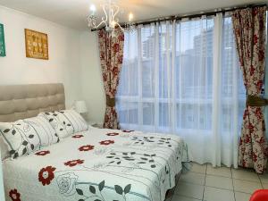 a bedroom with a bed and a large window at Depto Metro Cal y Canto (Estudio) in Santiago