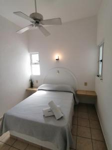 1 dormitorio blanco con 1 cama y ventilador de techo en Htl & Suites Neruda, ubicación, limpieza, facturamos en Colima