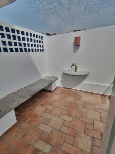 La salle de bains est pourvue d'un banc et d'un lavabo mural. dans l'établissement Htl & Suites Neruda, ubicación, limpieza, facturamos, à Colima