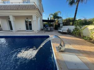 una piscina con una fuente frente a una casa en Luxury spacious holiday Villa with heated swimming pool, en Paralimni