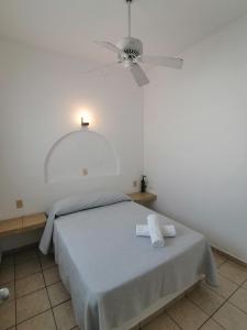 1 dormitorio con 1 cama y ventilador de techo en Htl & Suites Neruda, ubicación, limpieza, facturamos, en Colima