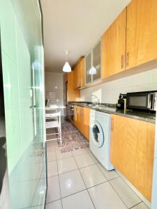 uma cozinha com uma máquina de lavar roupa e uma máquina de lavar roupa em University of Minho- INL Campus Gualtar Apartment 2 em Braga