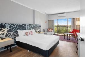 卡尔古利The Plaza Hotel Kalgoorlie的带床和阳台的酒店房间