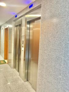 une rangée de portes d'ascenseur dans un bâtiment dans l'établissement University of Minho- INL Campus Gualtar Apartment 2, à Braga