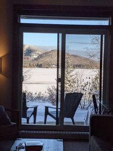 a view of a snow covered yard from a window at Escapade Bonheur in Lac-Superieur +45 photos