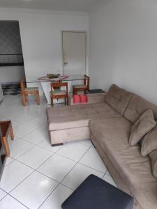 uma sala de estar com um sofá e uma mesa em Enseada- 400m Aquário. Apt espaçoso e aconchegante no Guarujá