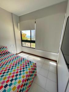 a bedroom with a bed and a window at Flat vista mar com estacionamento incluído in Salvador