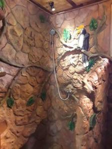 ein Badezimmer mit einer Felswand mit einem Vogel an der Wand in der Unterkunft Treehouse Holidays-Love Nest in Ko Yao Noi