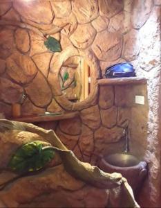 ein Steinbad mit einem WC in einer Steinwand in der Unterkunft Treehouse Holidays-Love Nest in Ko Yao Noi