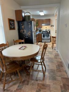 uma cozinha com uma mesa e cadeiras e um frigorífico em The Blue House em Ironwood
