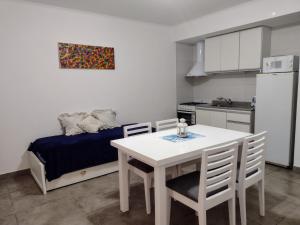 - une cuisine et une salle à manger avec une table et un lit dans l'établissement Departamento Ezeiza- ciudad de Tandil, à Tandil