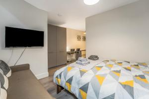 a bedroom with a bed and a flat screen tv at Relaxing & Cozy Studio Apartment - Oasis in the Heart of Edinburgh - Sleeps Up to 3 Guests in Edinburgh