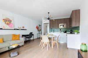 un soggiorno e una cucina con divano e tavolo di The Monkey House apartment - A jungle of comfort a Costa Teguise