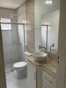 a bathroom with a sink and a toilet and a mirror at Apartamento encantador em Seabra in Seabra