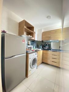 a kitchen with a refrigerator and a washing machine at MrK Penthouse at Timurbay in Kuantan