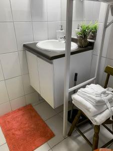 a white bathroom with a sink and a chair at Depto Metro Cal y Canto (Estudio) in Santiago +50 photos