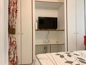 a bedroom with a bed and a television on a shelf at Depto Metro Cal y Canto (Estudio) in Santiago