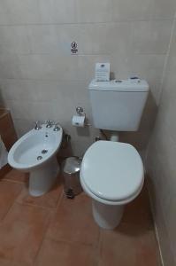 a bathroom with a white toilet and a sink at Complejo "Nahuel Pan " in El Chalten