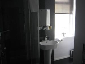 a black bathroom with a sink and a window at The Dragonfly in Blackpool