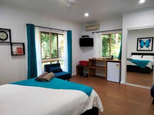 a bedroom with a bed and a desk and window at Vista Hinchinbrook in Cardwell
